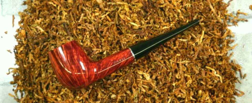 Close up of a pipe with burning Burley tobacco emitting aroma.